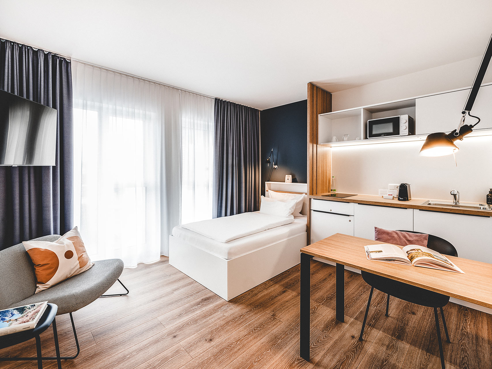 Modernes Apartment mit Einzelbett und offener Küchenzeile in einer Unterkunft in Herzogenaurach