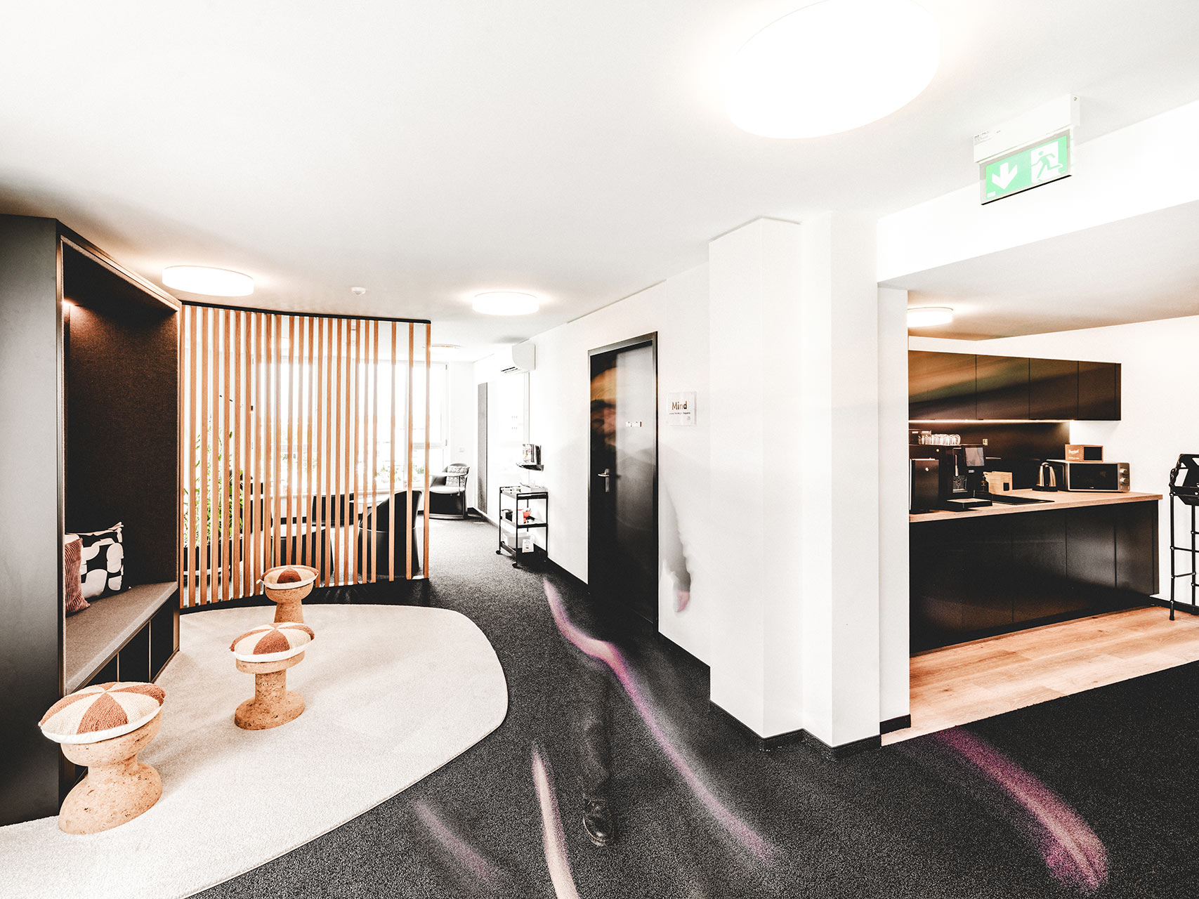 Stilvoller Flurbereich zum Coworking Space mit Sitzhockern und Küchenzeile