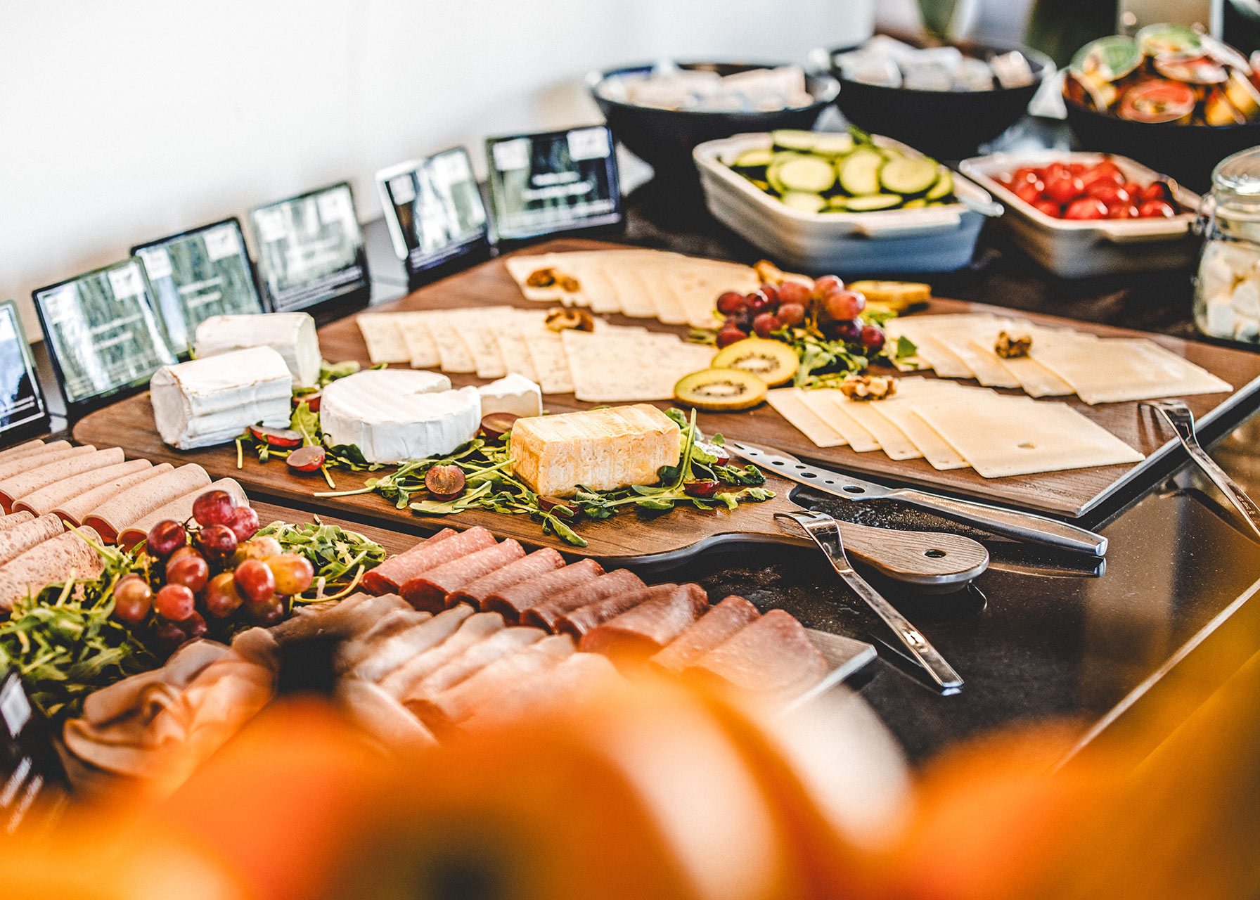 Käse- und Wurstplatte mit Trauben und frischem Gemüse auf dem Frühstücksbuffet