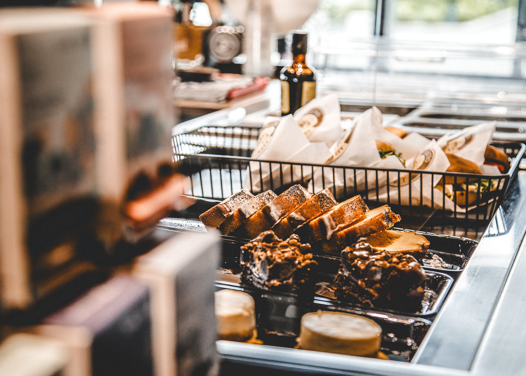 Nahaufnahme der Auslagetheke mit belegten Sandwiches, Kuchenstücken und Brownies