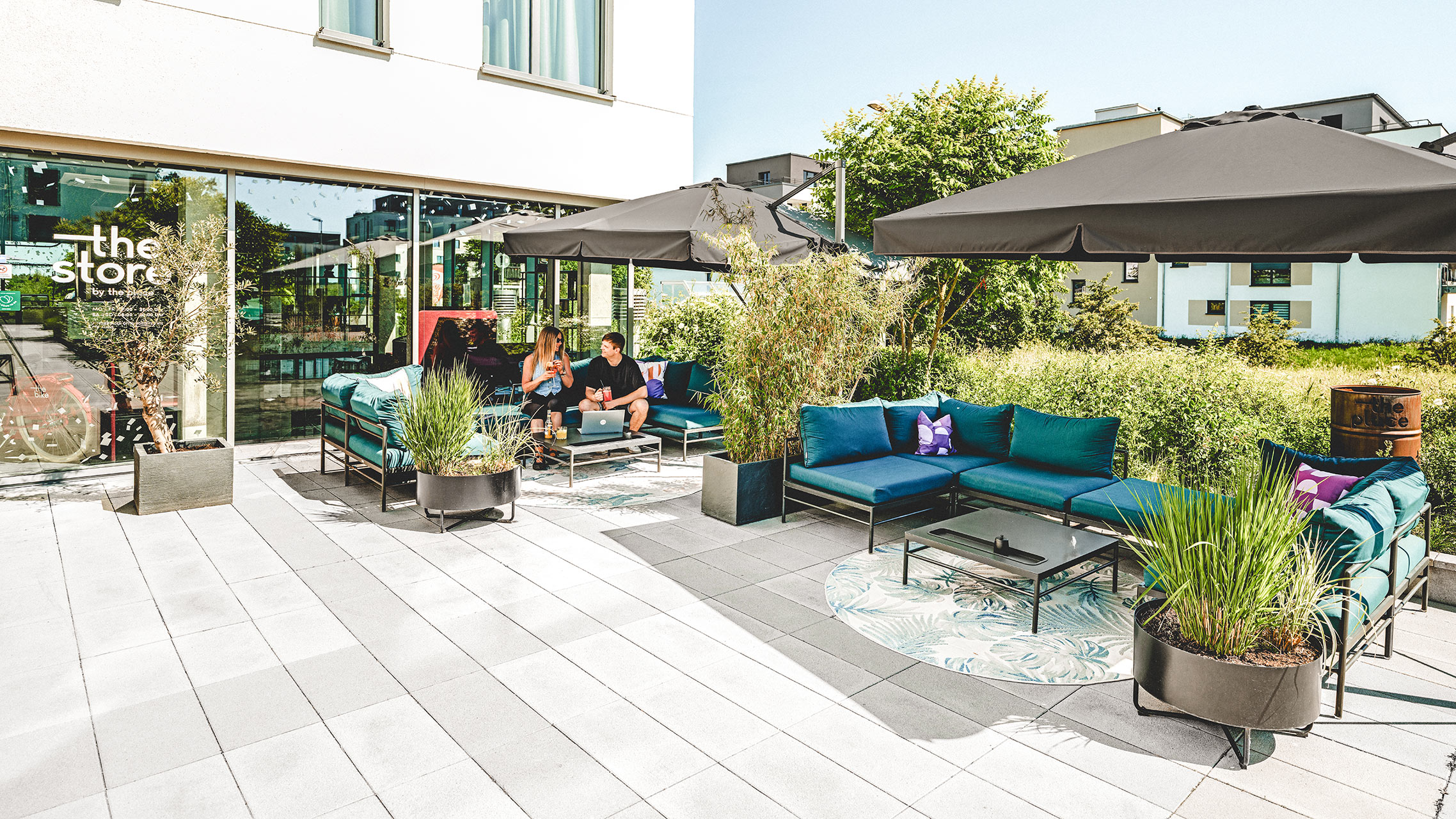 Terrasse der Serviced Apartments in Herzogenaurach mit Sitzbereich und Sonnenschirmen