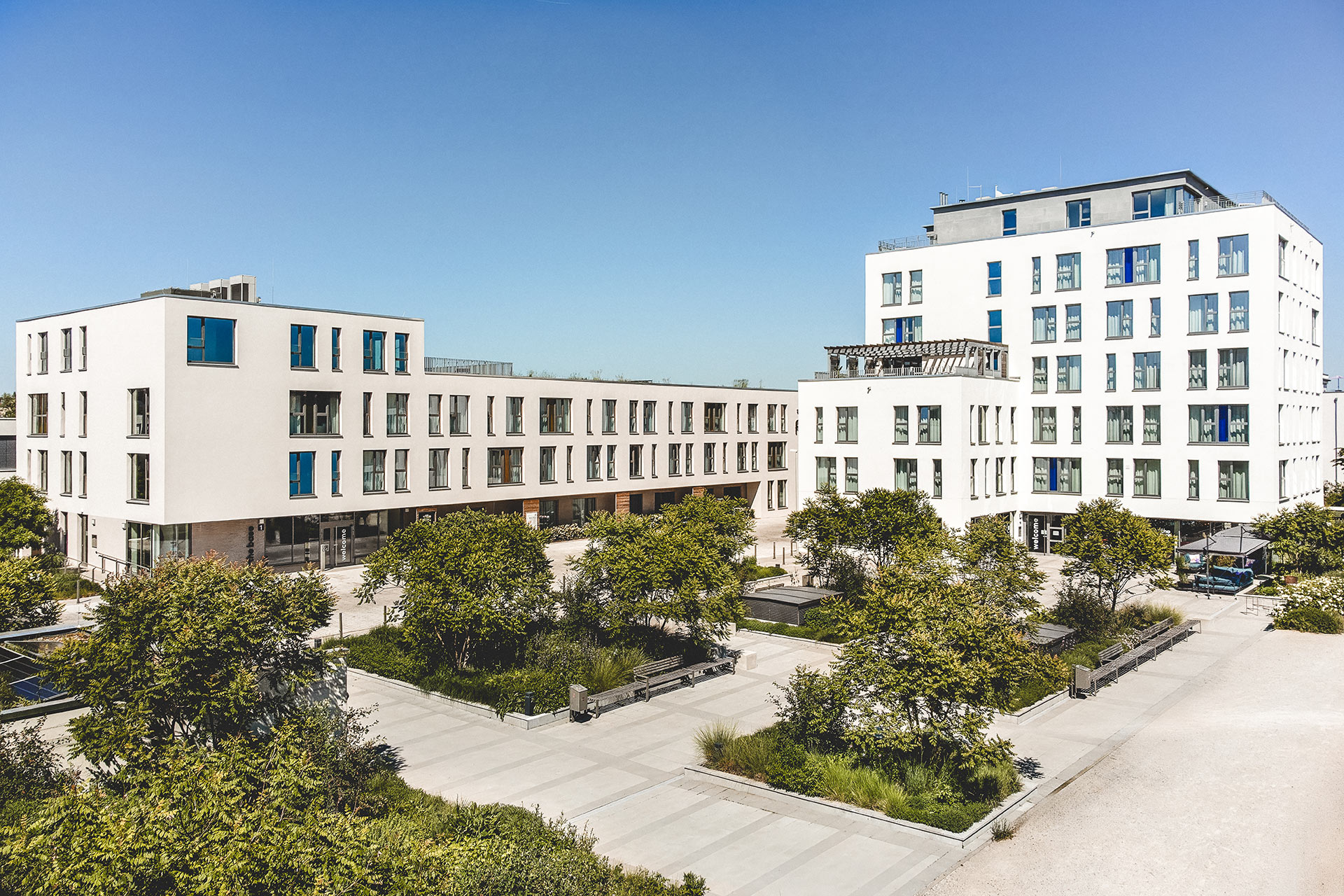 Außenansicht der Serviced Apartments in Herzogenaurach mit begrüntem Vorplatz